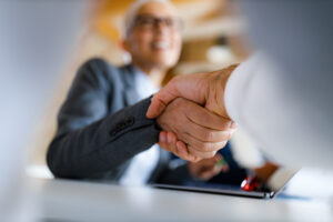 Close up of two people shaking hands in the office.