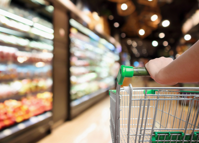 Shopping cart being pushed inside grocery store.